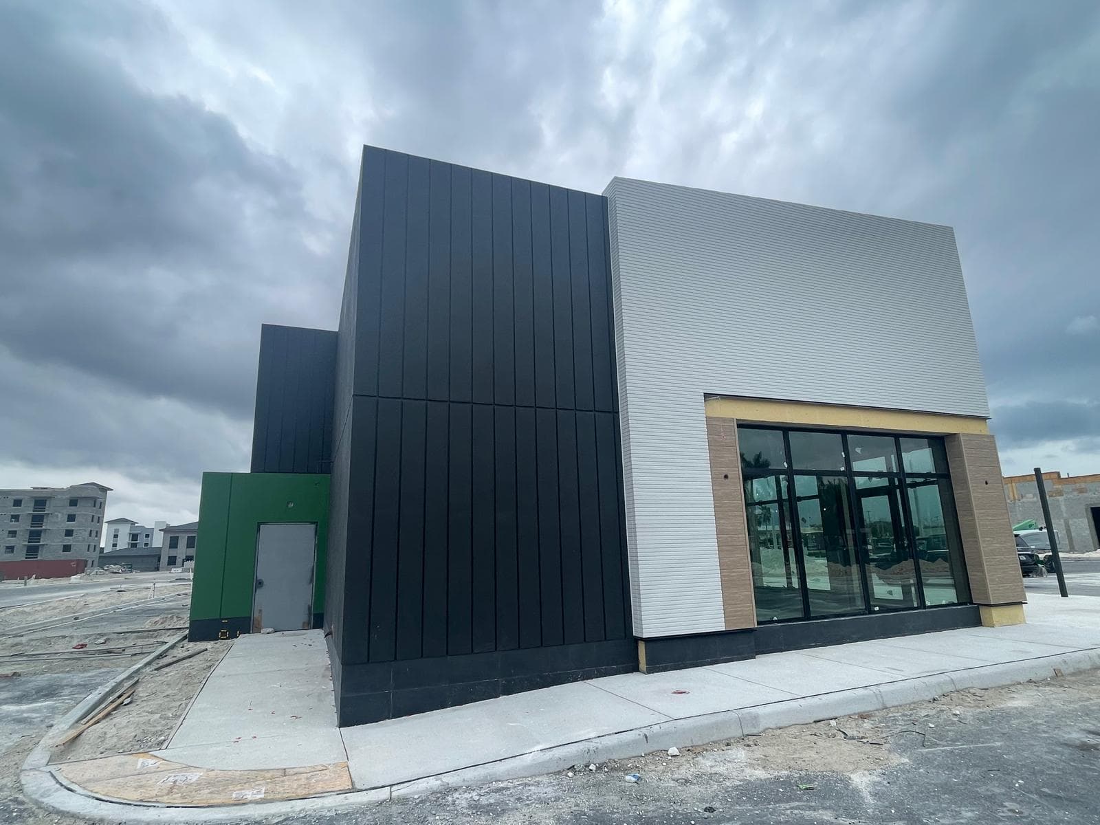 General construction project exterior with completed facade and storefront glazing
